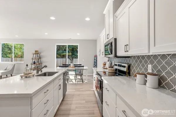 a kitchen with sink a stove and cabinets