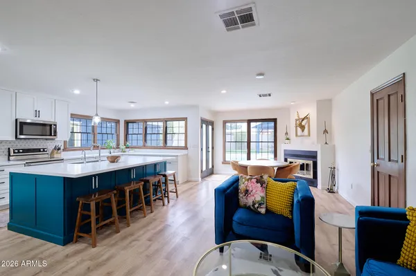 a large kitchen with stainless steel appliances kitchen island granite countertop a table chairs in it and a wooden floors