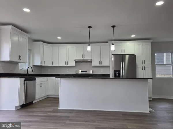 a large kitchen with stainless steel appliances granite countertop a stove a sink and a refrigerator