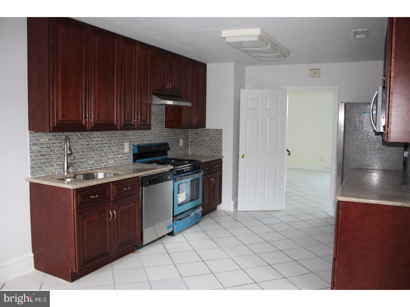 1213 Manoa Road Wynnewood, PA 19096 - Photo 2 of 8 a kitchen with stainless steel appliances granite countertop a stove a sink and a refrigerator