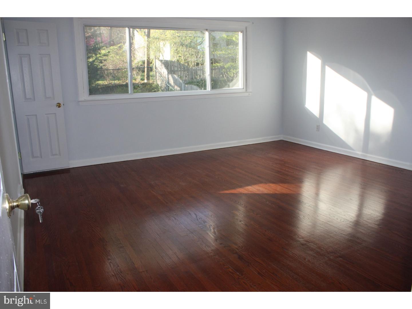 1213 Manoa Road Wynnewood, PA 19096 - Photo 5 of 8 an empty room with wooden floor and windows