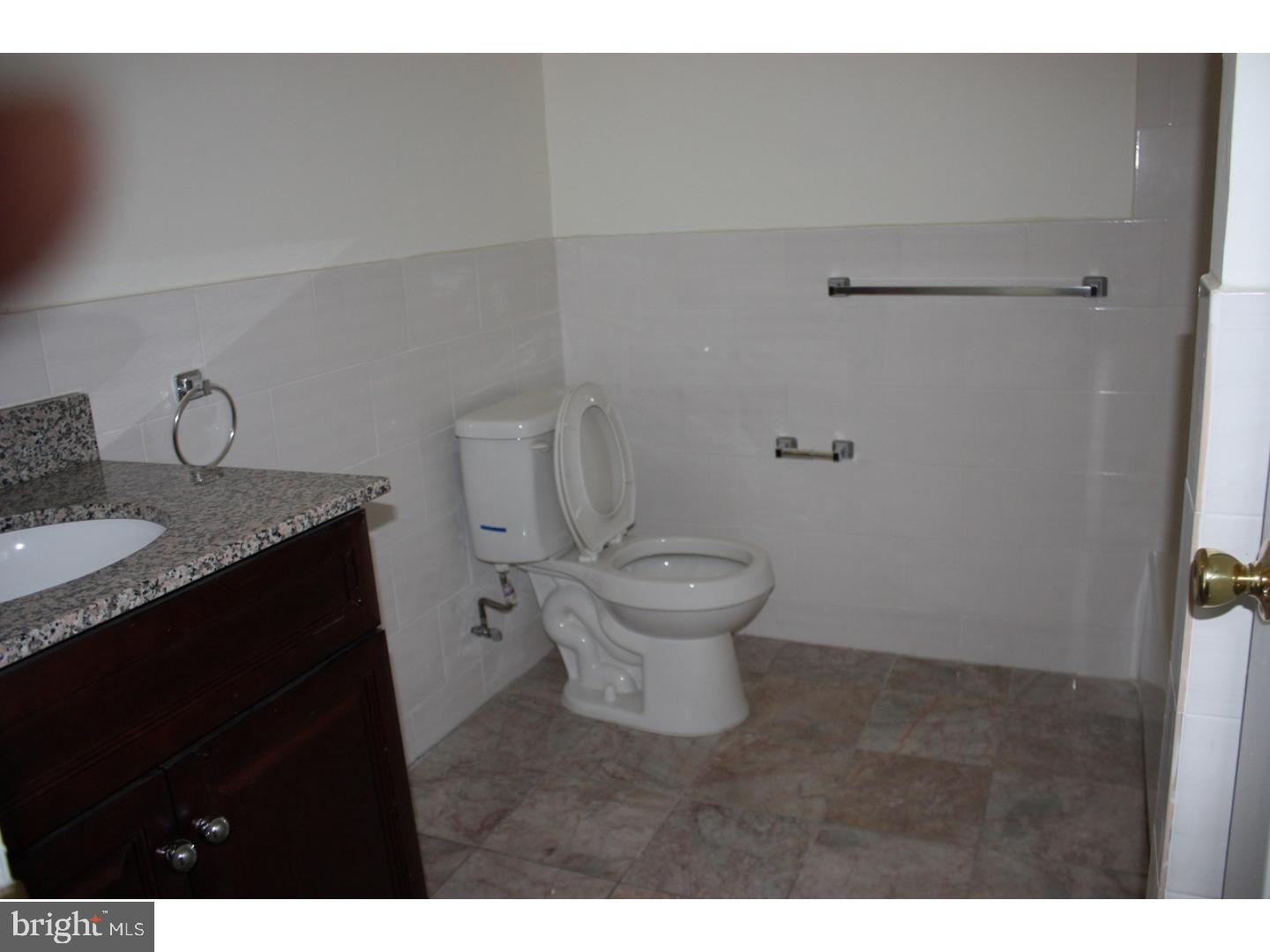 1213 Manoa Road Wynnewood, PA 19096 - Photo 6 of 8 a bathroom with a granite countertop sink toilet and a mirror