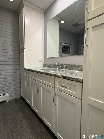 a bathroom with a granite countertop sink and a mirror