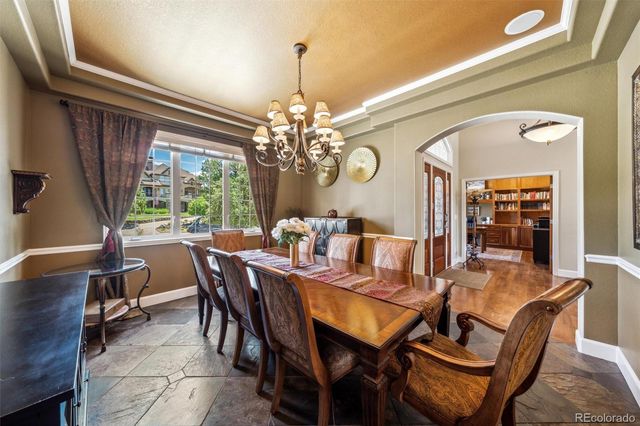 a dining room with furniture a chandelier and window