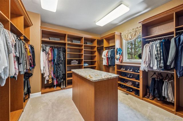 a view of walk in closet with clothes and shoes