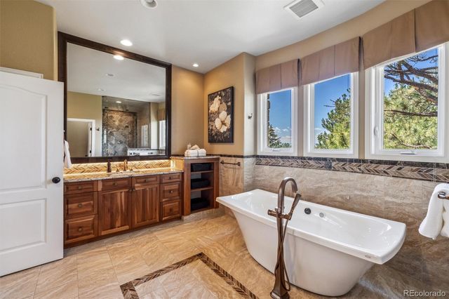 a large bathroom with a tub a sink and a large mirror