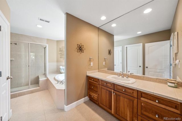 a bathroom with a granite countertop bathtub shower and mirror