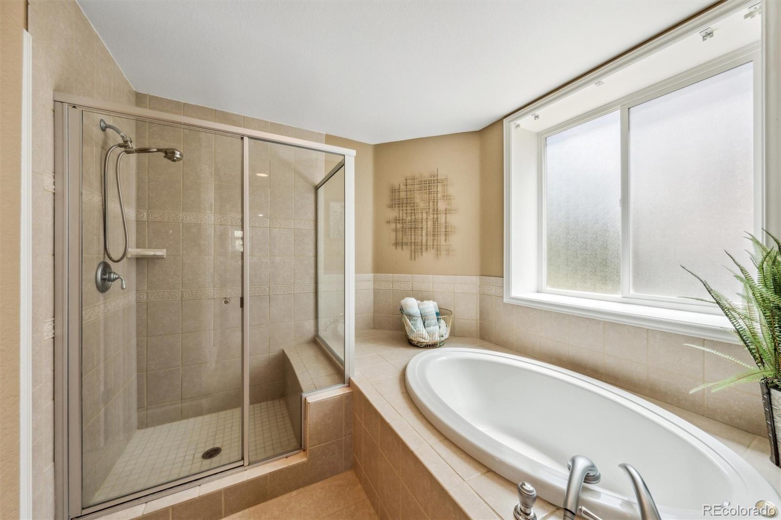 5159 Warbler Court Parker, CO 80134 - Photo 32 of 50 a bathroom with a granite countertop bathtub shower and mirror