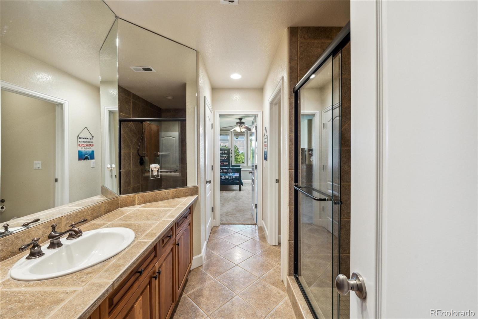 5159 Warbler Court Parker, CO 80134 - Photo 34 of 50 a spacious bathroom with a sink a shower and a mirror