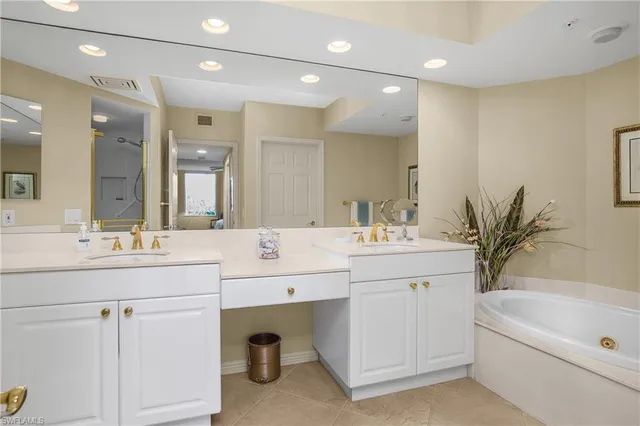 a bathroom with a granite countertop sink a large mirror a shower and bathtub