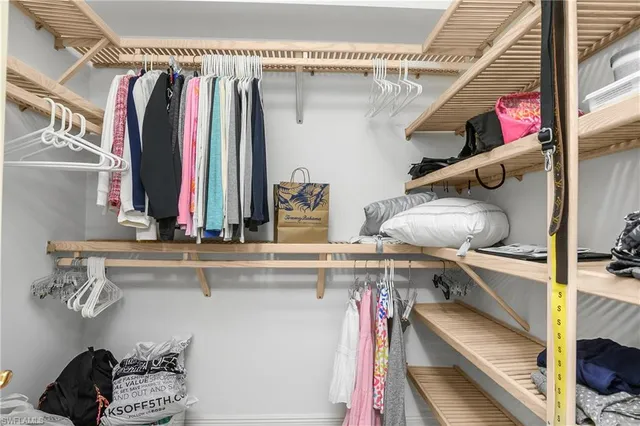 a view of walk in closet with clothes and shoes