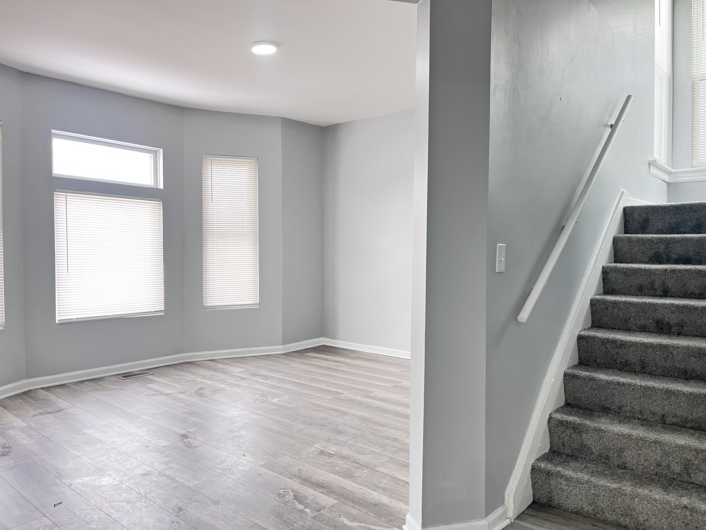 10739 South State Street Chicago, IL 60628 - Photo 11 of 14 a view of an empty room with wooden floor and stairs