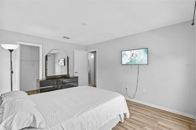 a bedroom with a large bed and a chandelier