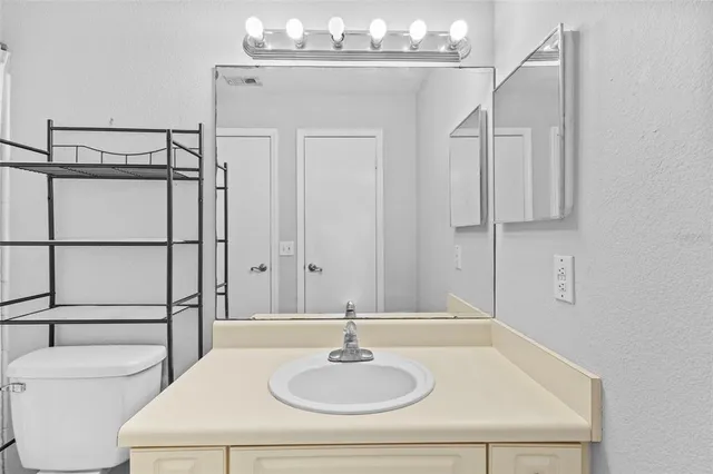 a bathroom with a sink and mirror with bathtub