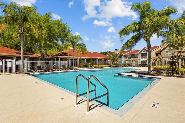 a view of a swimming pool with a garden and trees