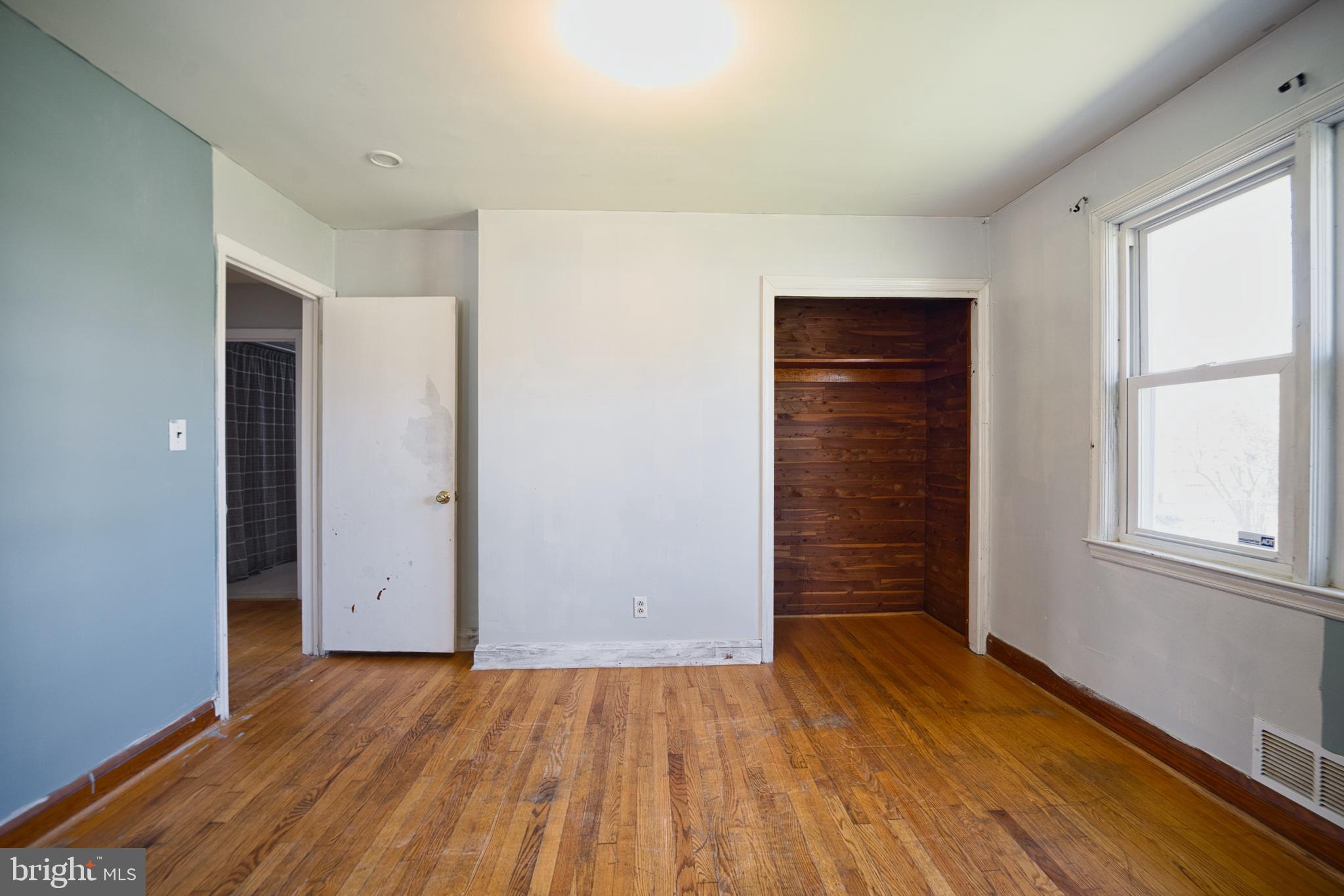 100 9th Avenue Baltimore, MD 21225 - Photo 15 of 38 an empty room with wooden floor and windows