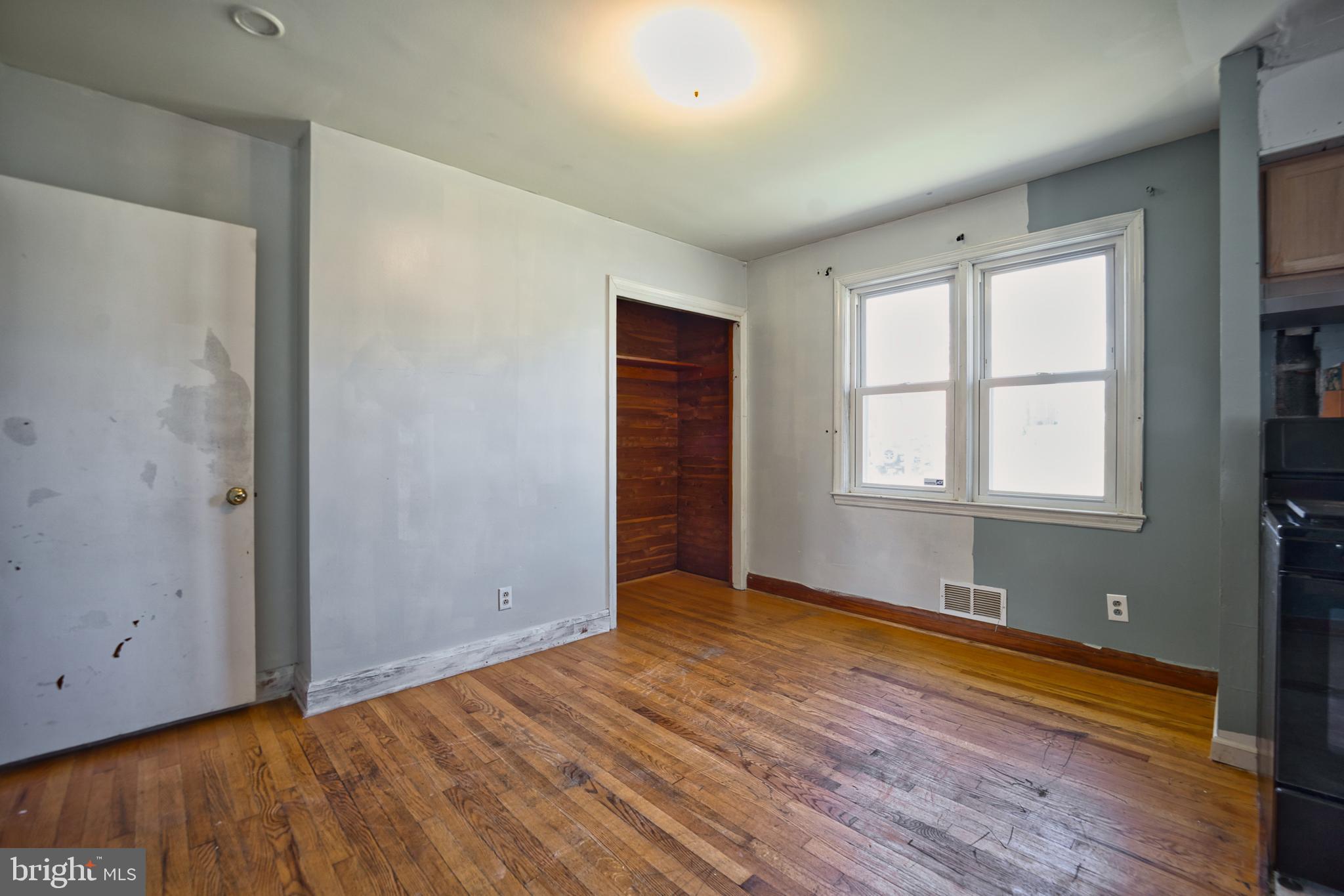 100 9th Avenue Baltimore, MD 21225 - Photo 16 of 38 a view of an empty room with wooden floor and a window