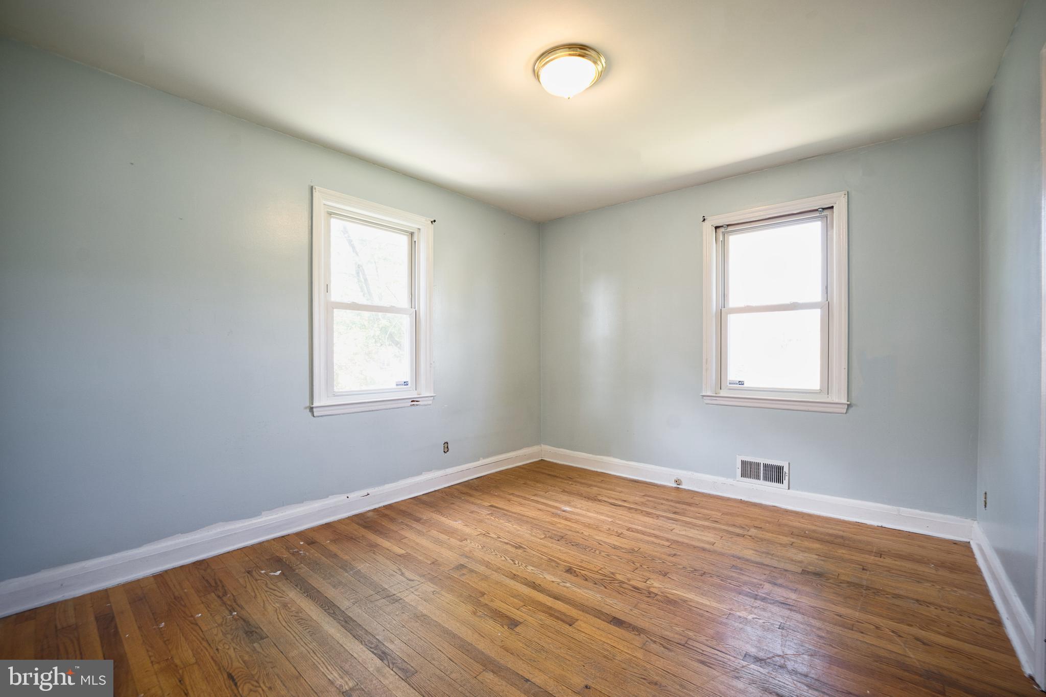 100 9th Avenue Baltimore, MD 21225 - Photo 22 of 38 an empty room with wooden floor and windows