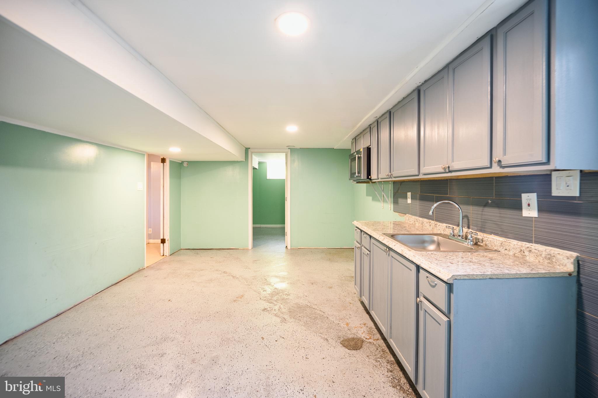 100 9th Avenue Baltimore, MD 21225 - Photo 37 of 38 a kitchen with a sink stove and cabinets