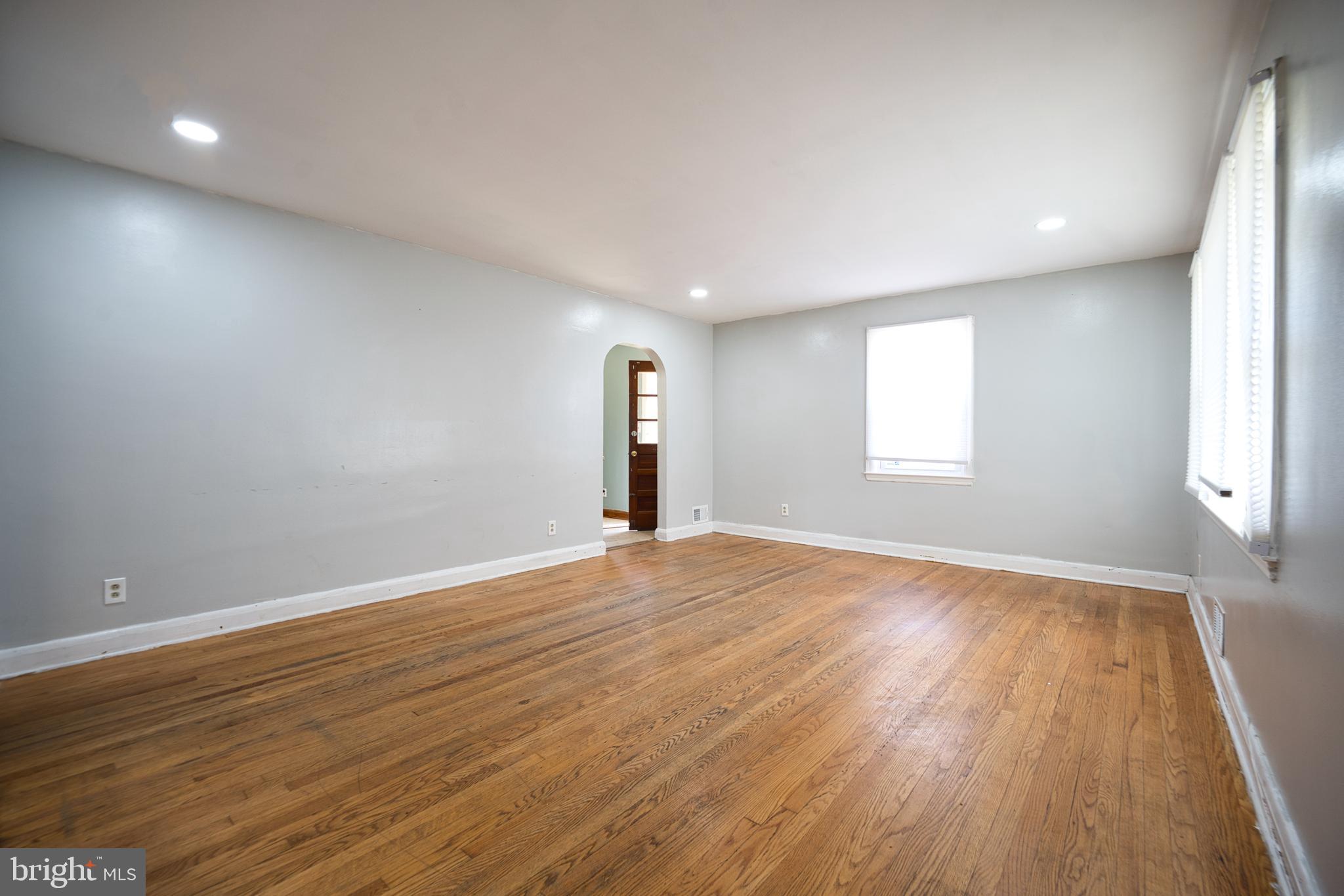 100 9th Avenue Baltimore, MD 21225 - Photo 8 of 38 an empty room with wooden floor and windows