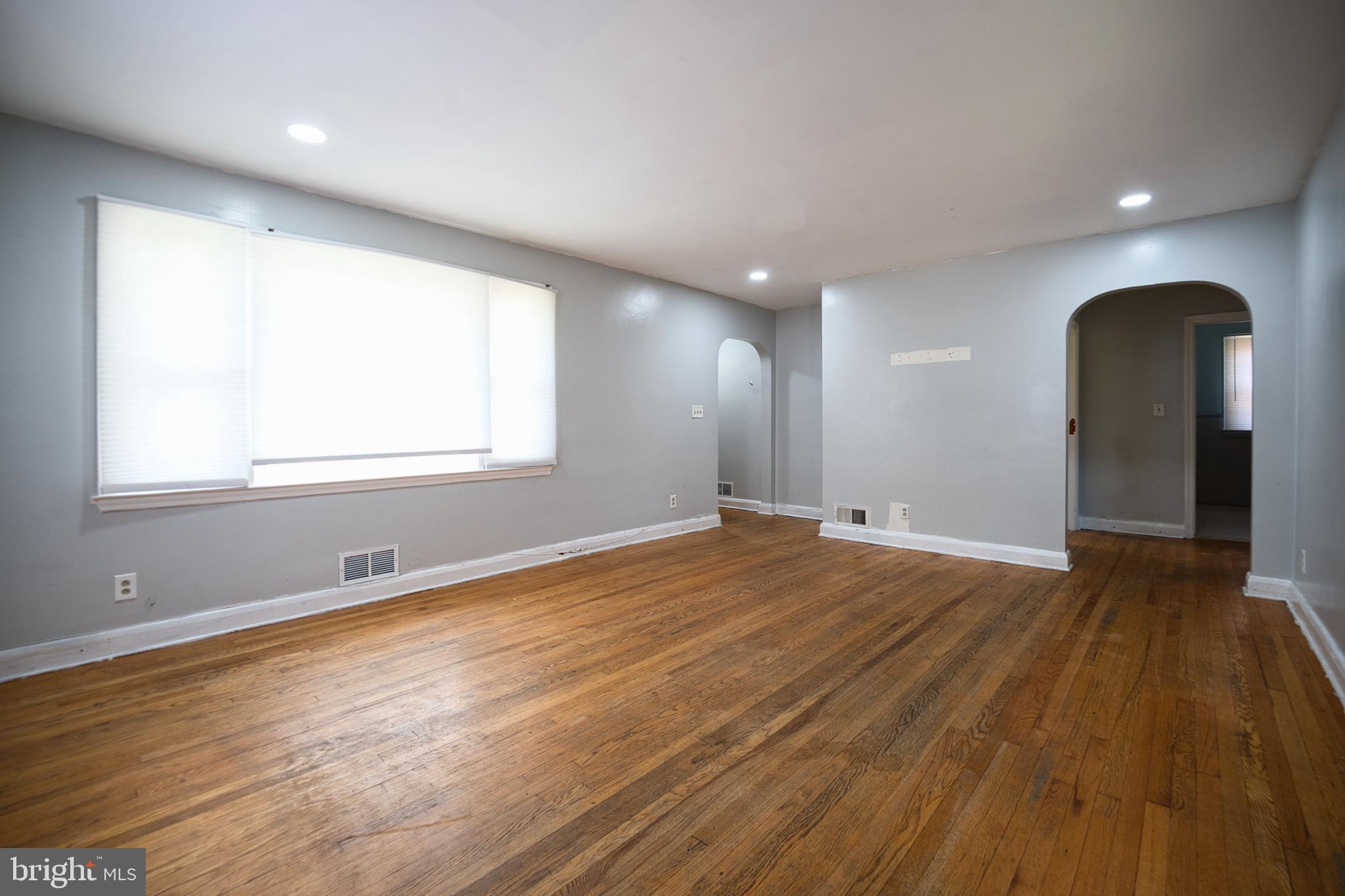 100 9th Avenue Baltimore, MD 21225 - Photo 10 of 38 an empty room with wooden floor and windows
