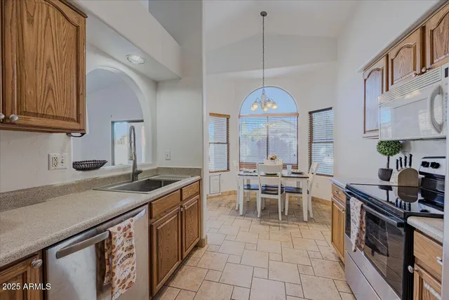 a kitchen with stainless steel appliances granite countertop a stove a sink and a refrigerator