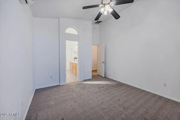 an empty room with a ceiling fan and a window