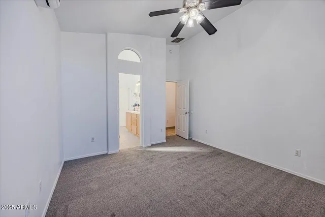 an empty room with a ceiling fan and a window