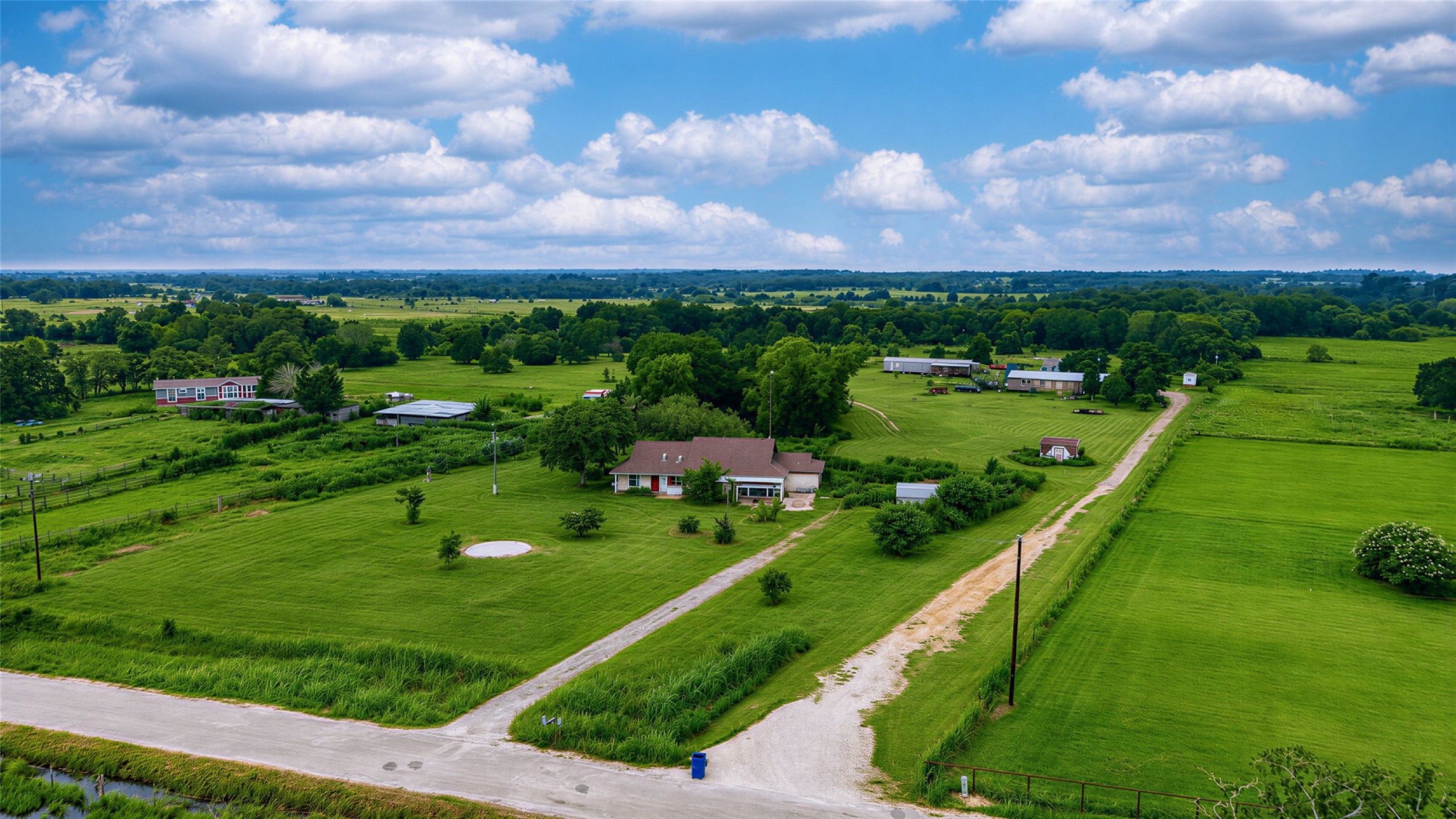 358 Easley Road Smithville, TX 78957 - Photo 35 of 36 An aerial perspective reveals a charming residence nestled amidst a verdant landscape with open fields.