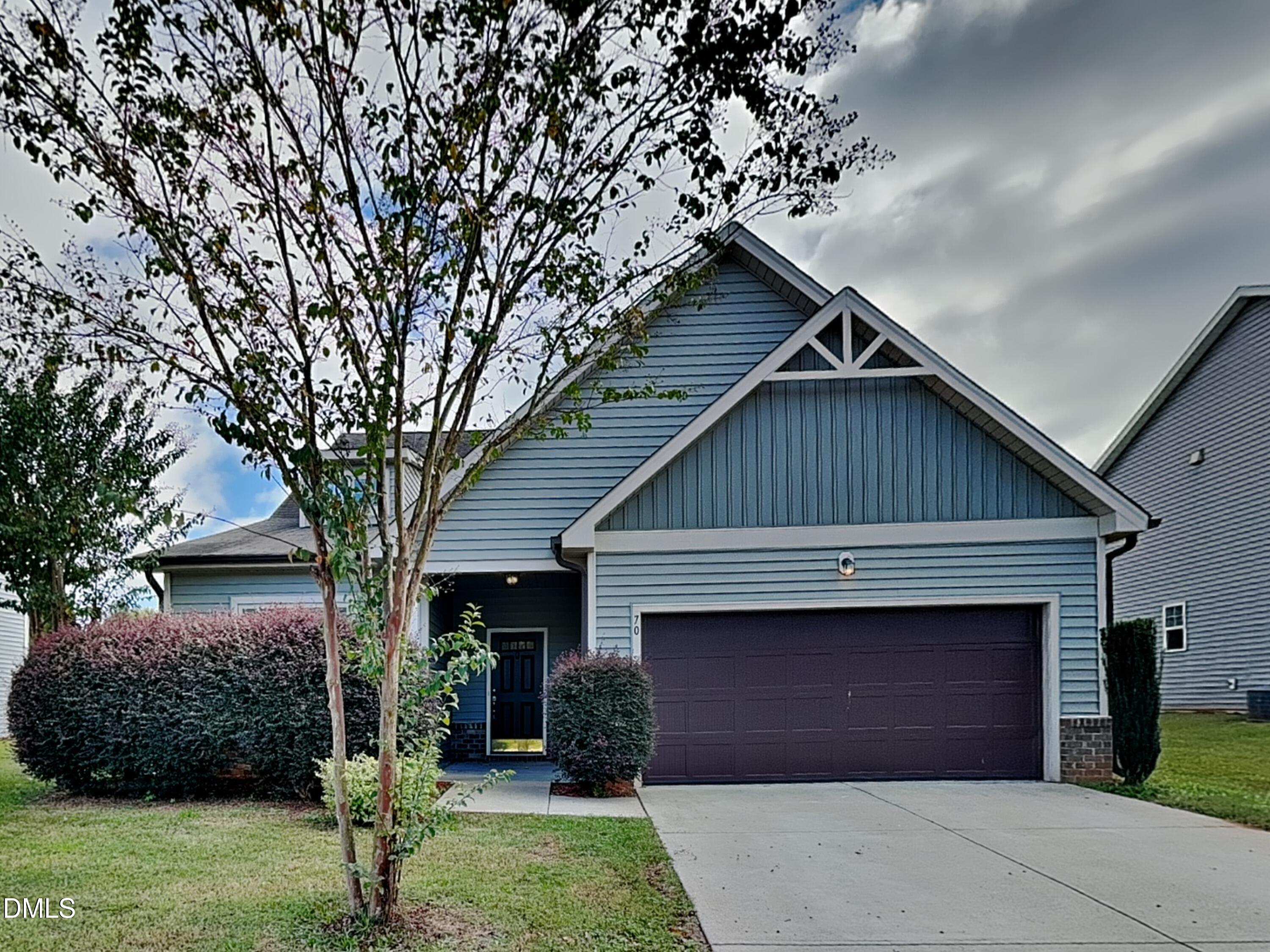 70 Leaf Spring Way Youngsville, NC 27596 - Photo 1 of 16 a front view of a house with a garden and trees