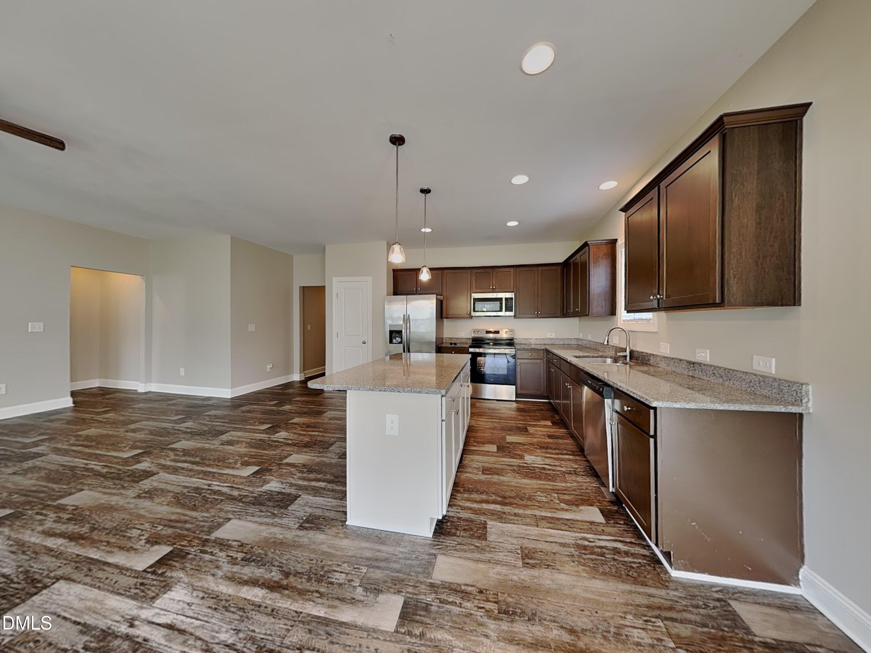 70 Leaf Spring Way Youngsville, NC 27596 - Photo 4 of 16 a large kitchen with stainless steel appliances kitchen island granite countertop a sink and a stove