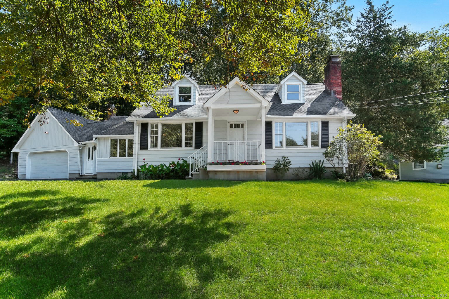 a front view of a house with a yard and trees