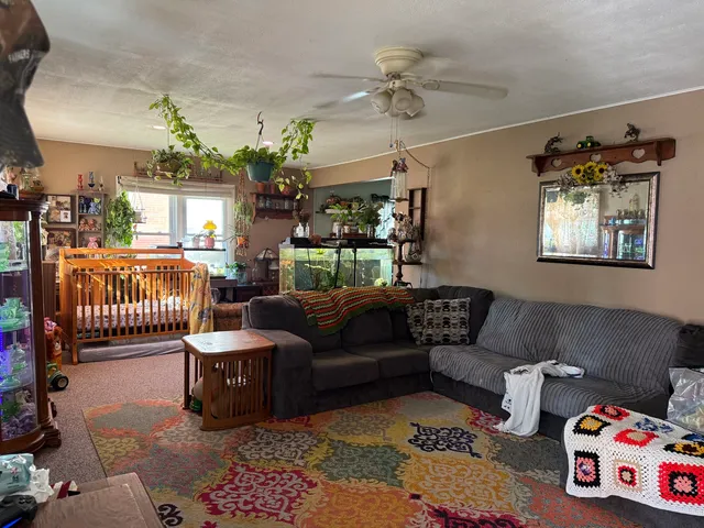 a living room with furniture and a baby crib