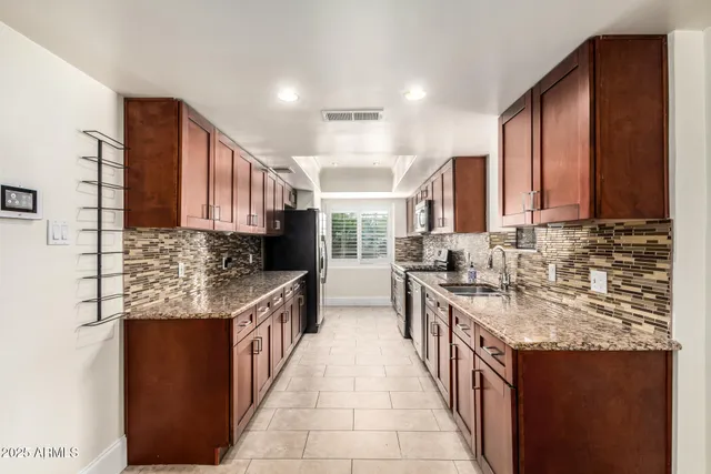 a kitchen with stainless steel appliances granite countertop a sink stove and cabinets