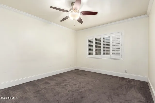 an empty room with a chandelier fan and closet