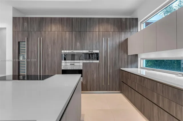 a kitchen with a refrigerator a stove a washer dryer and white cabinets