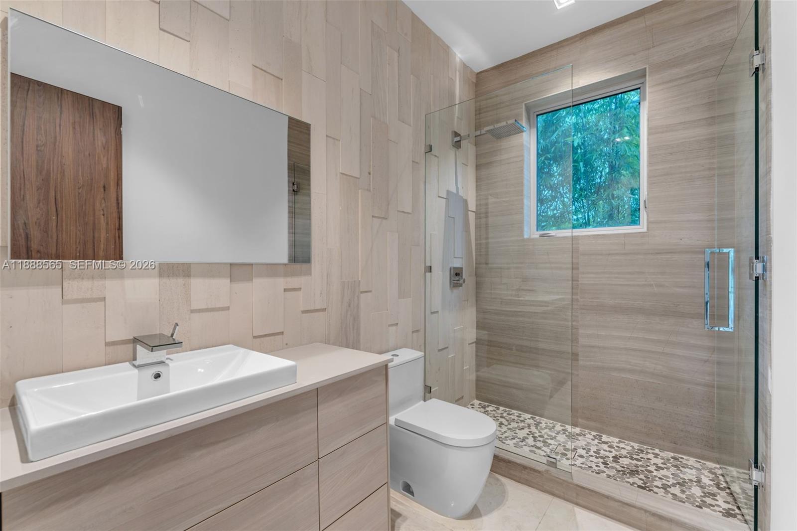 9101 Southwest 69th Court Pinecrest, FL 33156 - Photo 59 of 69 a bathroom with a sink toilet a mirror and shower