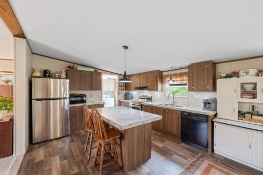 7112 Cobb Road Christiana, TN 37037 - Photo 4 of 22 a kitchen with a refrigerator a stove a sink a dining table and chairs