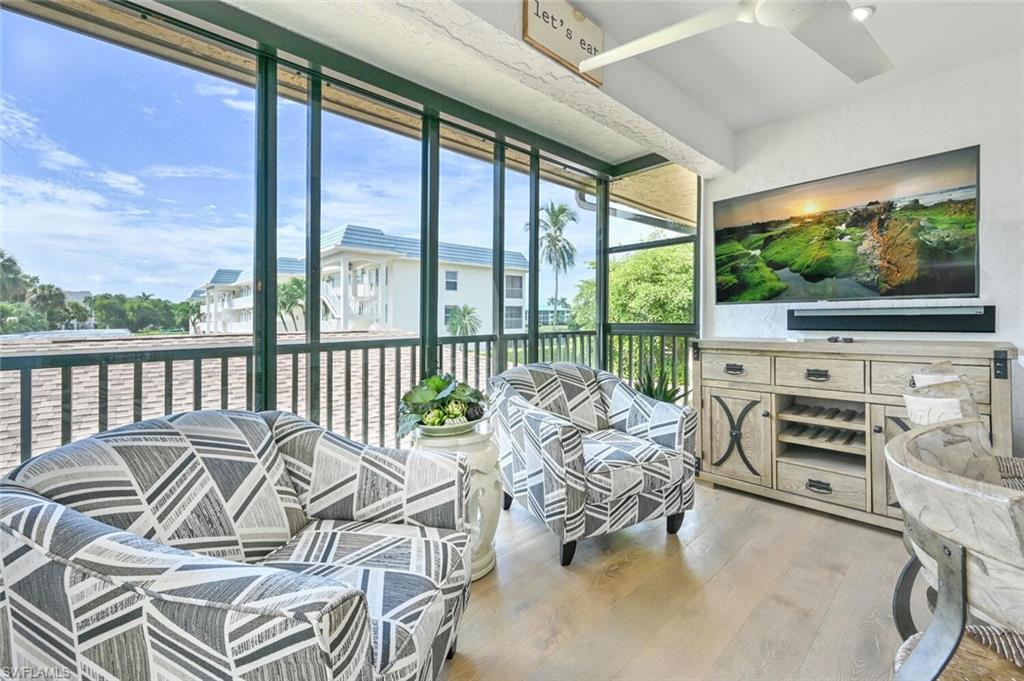 a living room with furniture tv and a large window