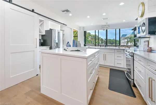 a kitchen with white cabinets and stainless steel appliances