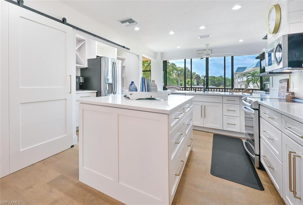 3105 Riviera Drive, Unit A201 Naples, FL 34103 - Photo 12 of 30 a kitchen with a sink stove and cabinets