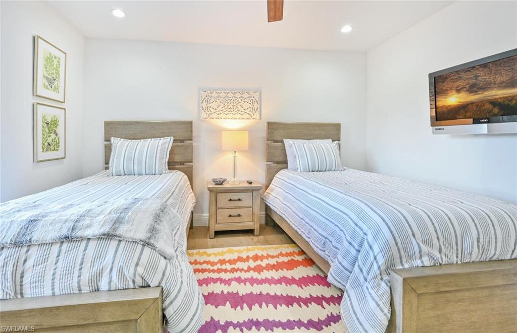 3105 Riviera Drive, Unit A201 Naples, FL 34103 - Photo 26 of 30 a bedroom with a bed and a flat screen tv