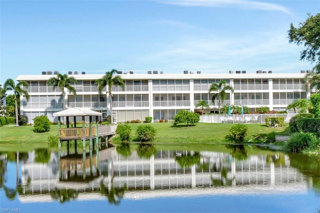 3105 Riviera Drive, Unit A201 Naples, FL 34103 - Photo 30 of 30 a view of a lake with a building in front of it