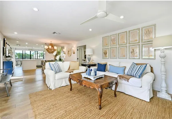 a living room with furniture wooden floor and a large window