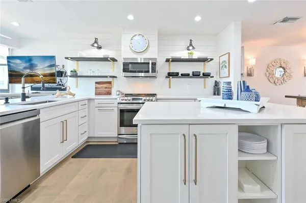 a kitchen with stainless steel appliances a stove microwave and cabinets