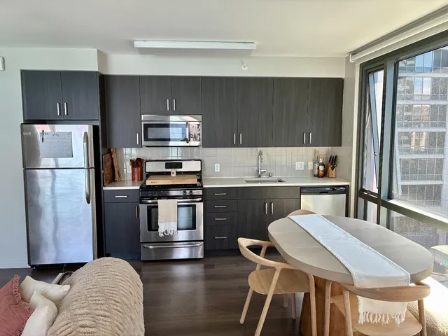 a kitchen with a refrigerator and a stove top oven