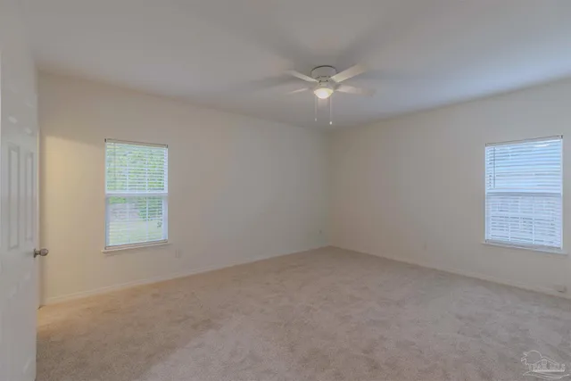 an empty room with a window and a fan