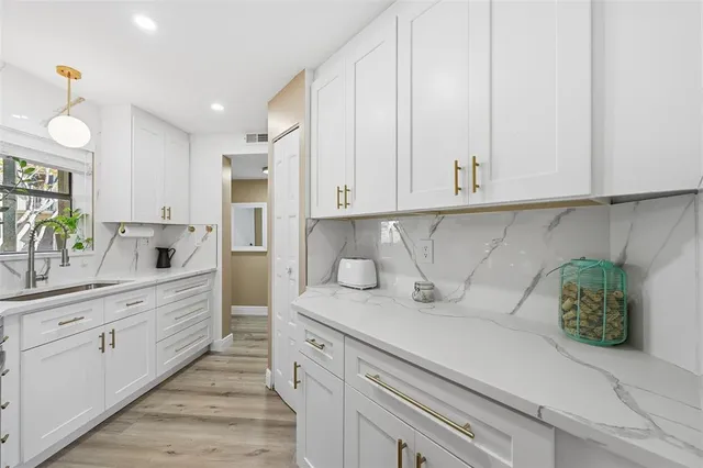 a kitchen with stainless steel appliances white cabinets and a sink
