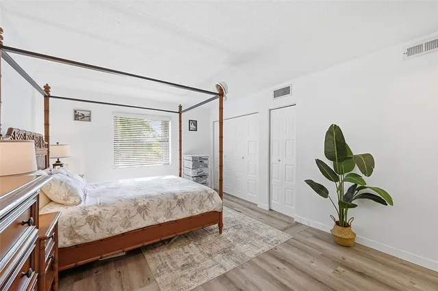 a bedroom with a bed and a potted plant