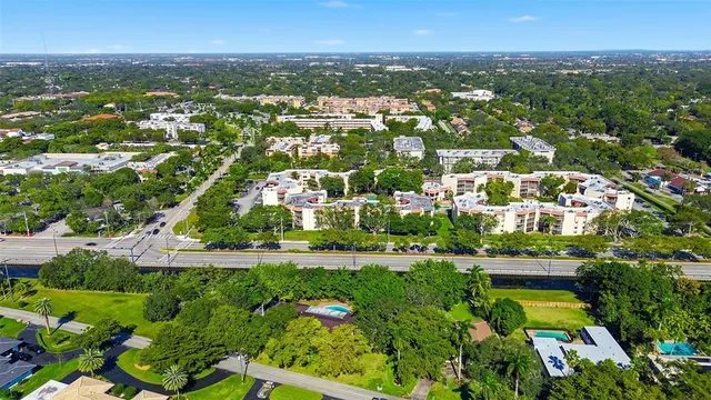 an aerial view of residential houses with outdoor space and trees